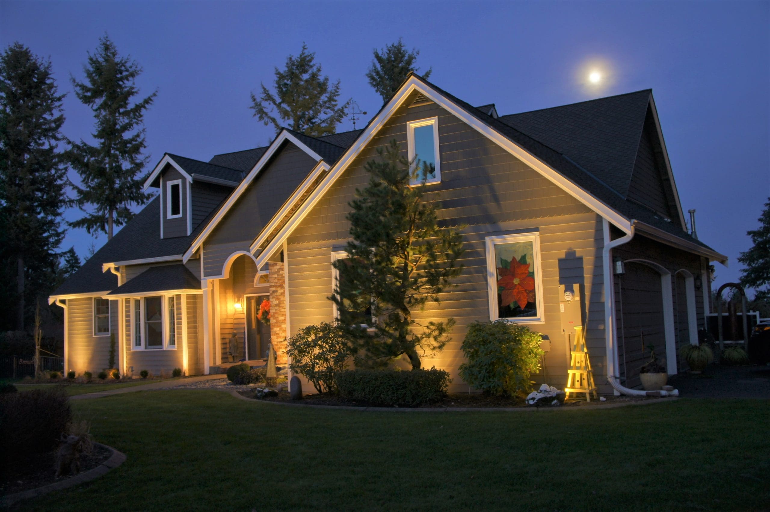 Home with landscape lighting illuminating the surface.